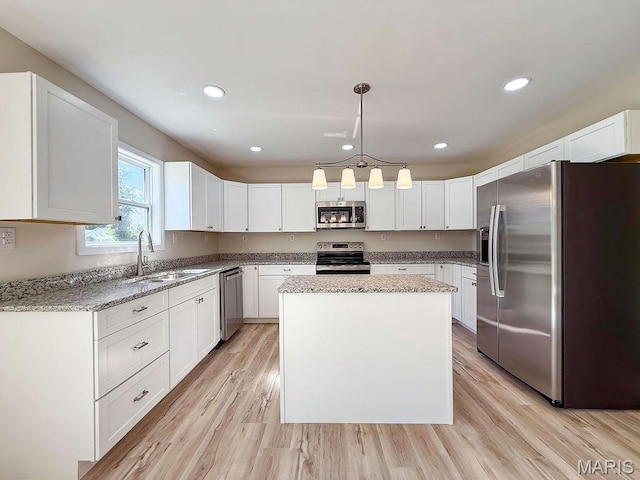 201 Ariel Ct, Desloge, MO 63601 - kitchen with appliances with stainless steel finishes, light stone counters, a kitchen island, white cabinets, and recessed lighting