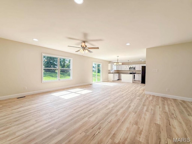 201 Ariel Ct, Desloge, MO 63601 - unfurnished living room with light wood finished floors, a ceiling fan, recessed lighting, and a chandelier