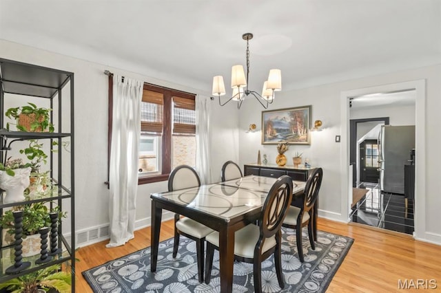 3644 Eminence Blvd, Saint Louis, MO 63114 - dining space with light wood-style flooring, a chandelier, and baseboards
