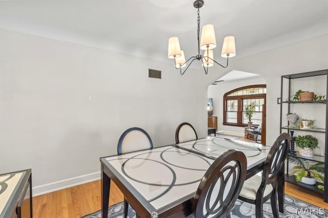 3644 Eminence Blvd, Saint Louis, MO 63114 - dining area with arched walkways, wood finished floors, baseboards, and a chandelier