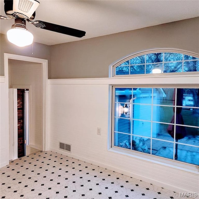 empty room featuring tile patterned floors and a ceiling fan