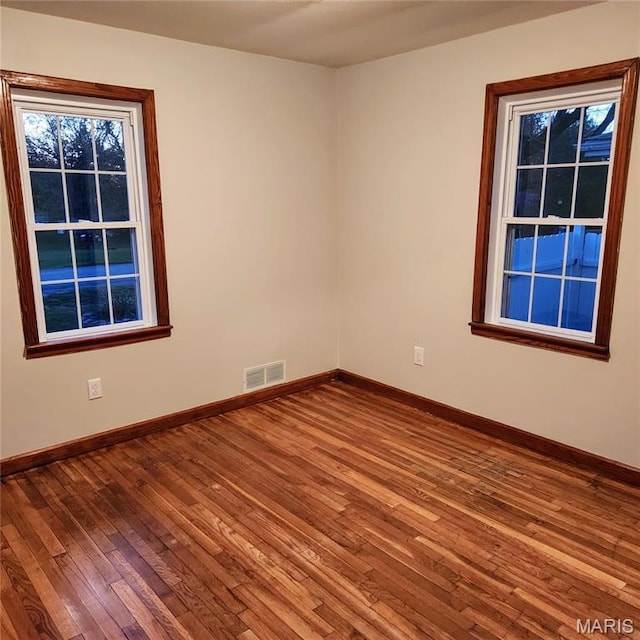 empty room featuring wood-type flooring and baseboards