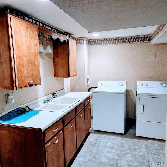 laundry room featuring washing machine and dryer, cabinet space, a textured ceiling, and light tile patterned floors