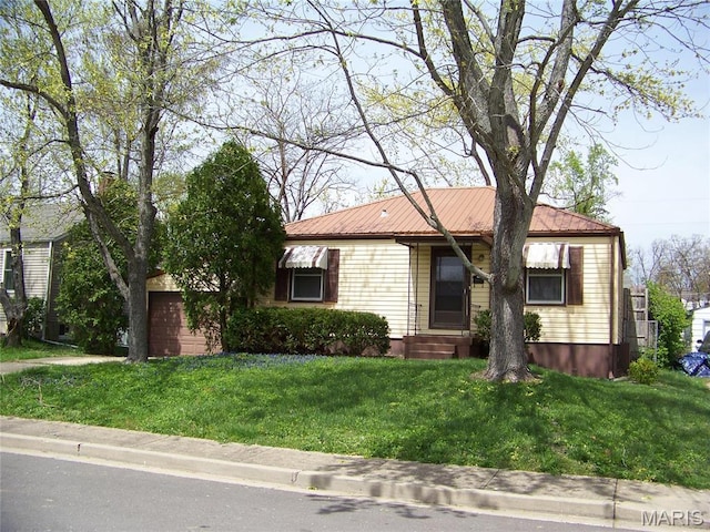 ranch-style home featuring a front lawn and metal roof