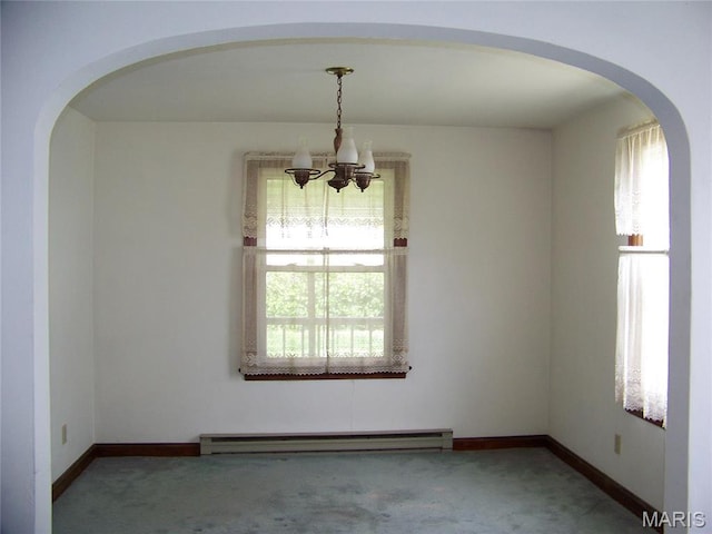 spare room with a baseboard radiator, carpet, a chandelier, and healthy amount of natural light