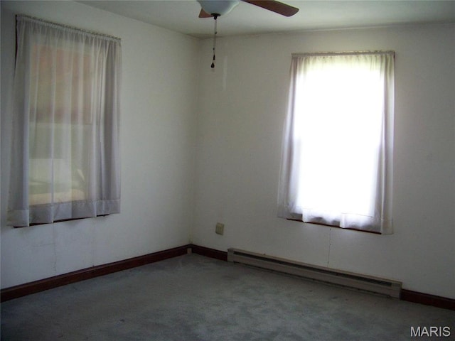 carpeted spare room with a baseboard radiator and ceiling fan