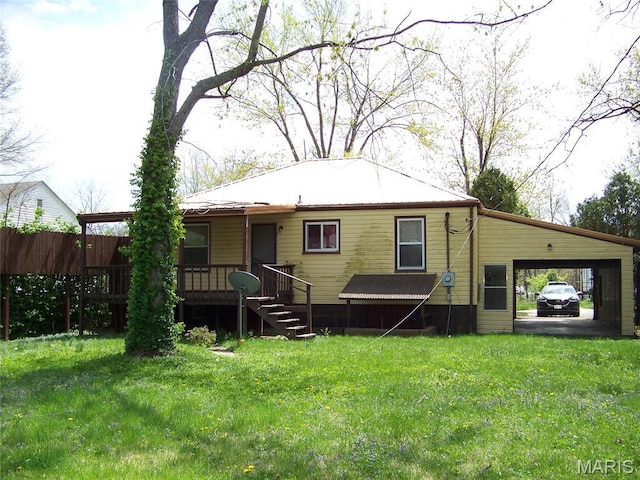 rear view of house featuring a lawn and an attached carport