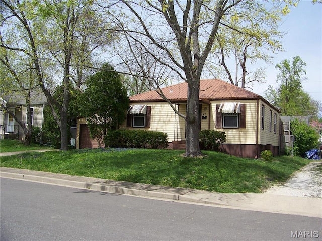 view of front of house with a front lawn and metal roof