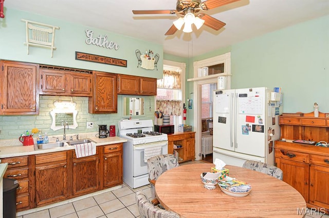 4207 Connecticut St, Saint Louis, MO 63116 - kitchen with white appliances, a ceiling fan, radiator heating unit, a sink, and decorative backsplash