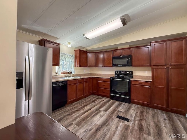 8325 Maple Ln, Dittmer, MO 63023 - kitchen with black appliances, a sink, lofted ceiling, light countertops, and dark wood-style flooring