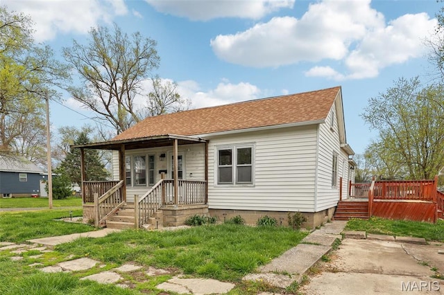 bungalow-style house featuring roof with shingles, a wooden deck, covered porch, and a front lawn