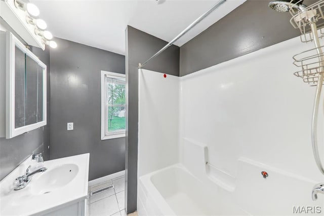 bathroom with tile patterned floors, vanity, baseboards, and  shower combination