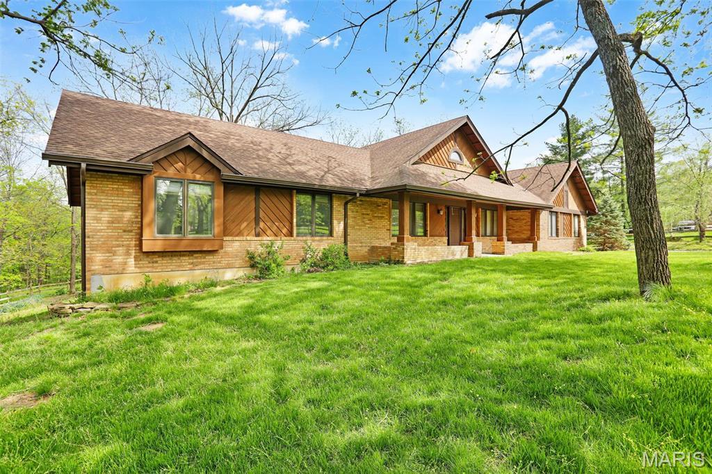 1808 Shiloh Valley Dr, Wildwood, MO 63005 - view of front of home with brick siding, covered porch, a front yard, and a shingled roof