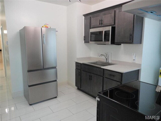6518 Chamberlain Ave, Saint Louis, MO 63130 - kitchen with stainless steel appliances, a sink, light countertops, baseboards, and dark brown cabinets