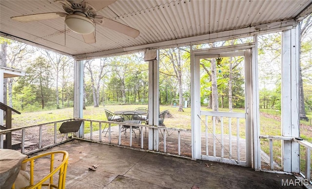 1109 Pawnee Dr, Cuba, MO 65453 - unfurnished sunroom featuring a ceiling fan, view of wooded area, and plenty of natural light