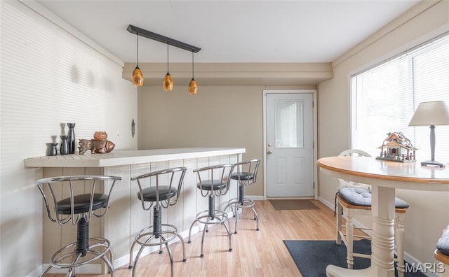 1109 Pawnee Dr, Cuba, MO 65453 - kitchen with light wood-style floors, a breakfast bar area, and pendant lighting