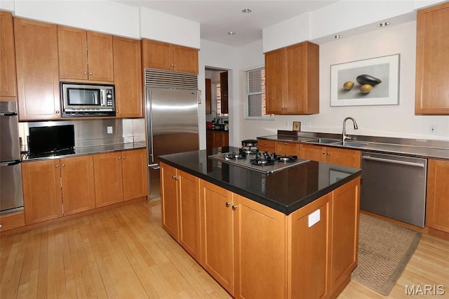 7788 Pershing Ave, Clayton, MO 63105 - kitchen with built in appliances, a sink, light wood finished floors, a kitchen island, and brown cabinets