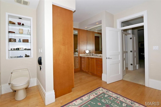 7788 Pershing Ave, Clayton, MO 63105 - bathroom with wood finished floors, vanity, toilet, and baseboards