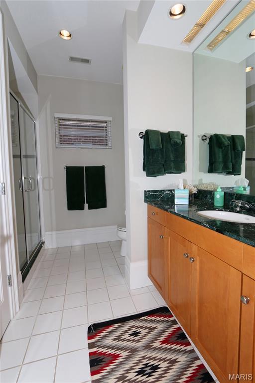 7788 Pershing Ave, Clayton, MO 63105 - full bath with vanity, tile patterned floors, a stall shower, toilet, and baseboards