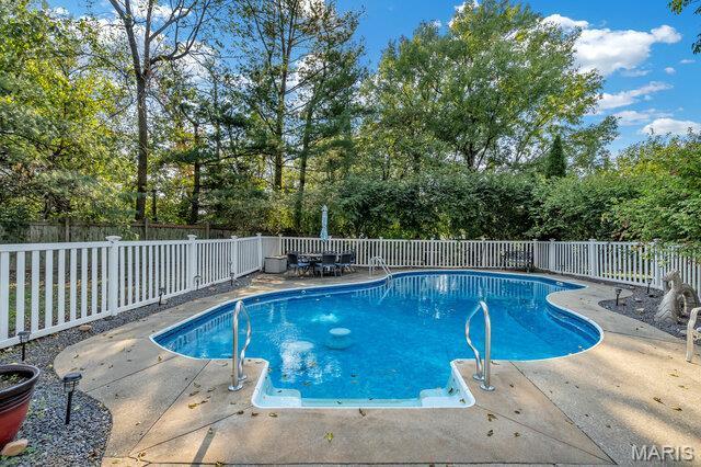 433 Snipes Dr, Saint Charles, MO 63303 - view of pool featuring a patio, a fenced backyard, and view of wooded area