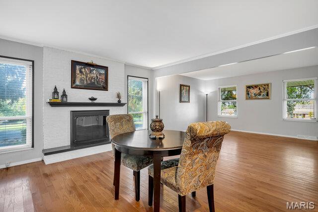 433 Snipes Dr, Saint Charles, MO 63303 - dining room featuring wood finished floors, healthy amount of natural light, a fireplace, and ornamental molding