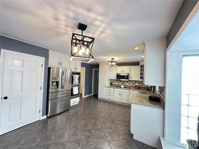 433 Snipes Dr, Saint Charles, MO 63303 - kitchen with appliances with stainless steel finishes, backsplash, white cabinetry, glass insert cabinets, and decorative light fixtures