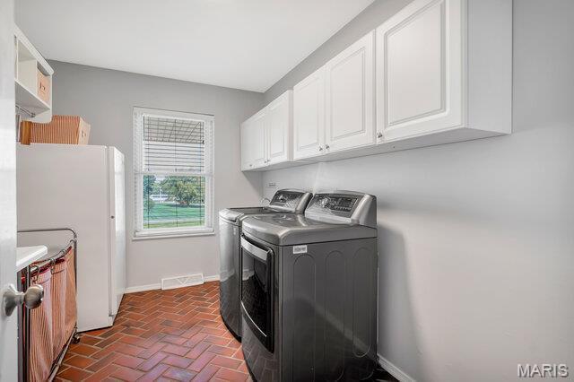 433 Snipes Dr, Saint Charles, MO 63303 - washroom featuring independent washer and dryer, cabinet space, and brick flooring