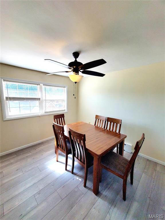 dining room featuring light wood-style flooring, baseboards, and ceiling fan