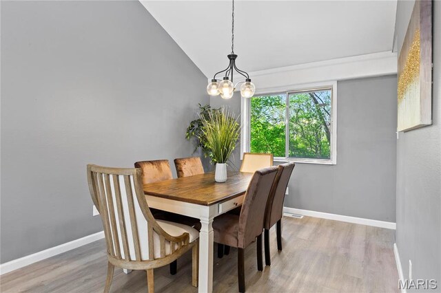 1958 Cathedral Hill Dr, Saint Louis, MO 63138 - dining area with light wood-style flooring, baseboards, vaulted ceiling, and a chandelier
