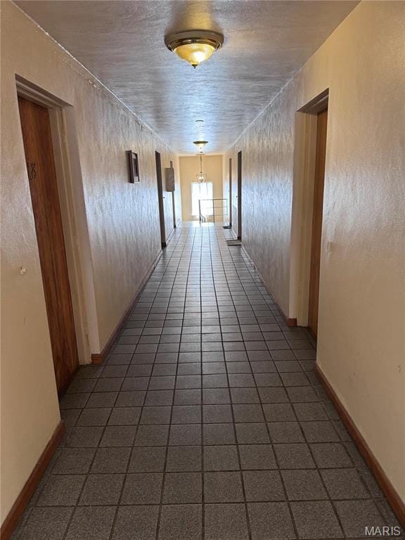 hall with tile patterned flooring and baseboards