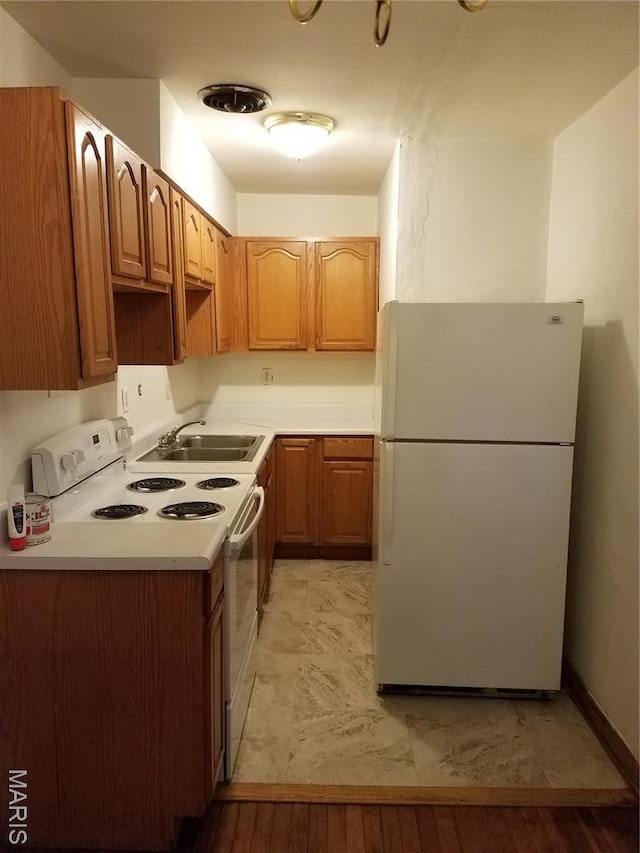 kitchen featuring white appliances, a sink, and light countertops
