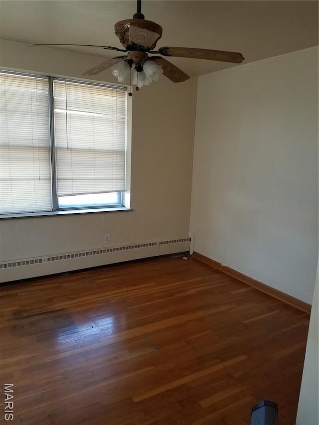 unfurnished room featuring baseboard heating, ceiling fan, wood finished floors, and baseboards