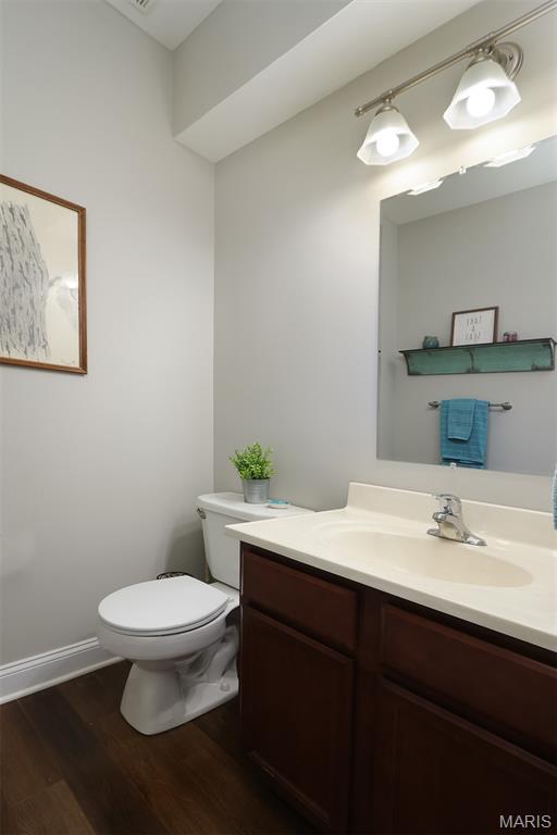2122 Birchwood Dr, Barnhart, MO 63012 - half bath featuring wood finished floors, toilet, vanity, and baseboards