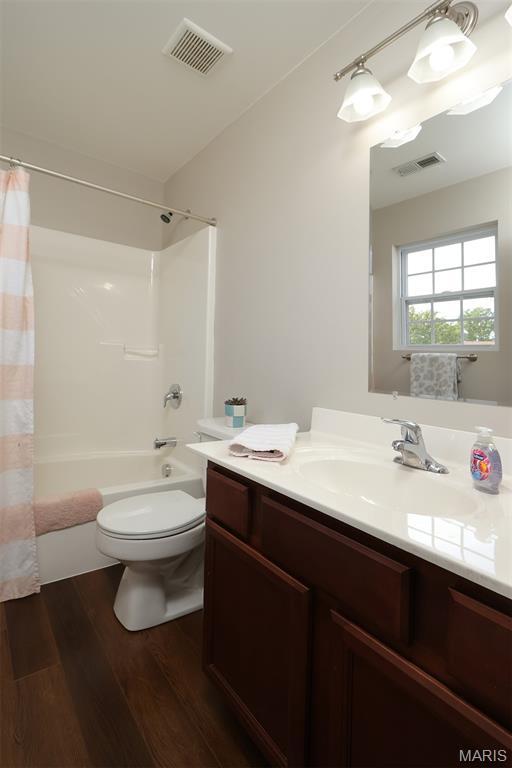 2122 Birchwood Dr, Barnhart, MO 63012 - full bathroom with wood finished floors, toilet, vanity, and shower / bath combo