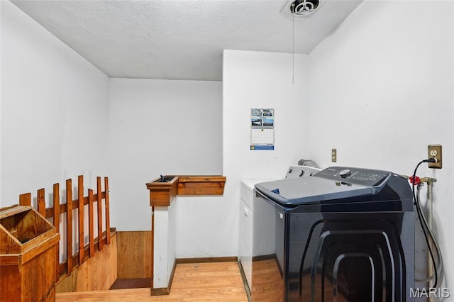 laundry room with independent washer and dryer and wood finished floors