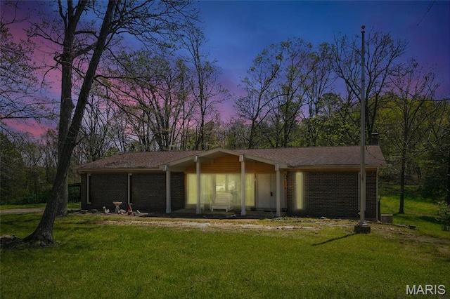 view of front facade featuring a front yard and brick siding