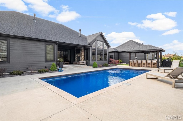 swimming pool with a patio and a gazebo