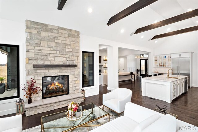 living area featuring dark wood finished floors, a stone fireplace, baseboards, and recessed lighting