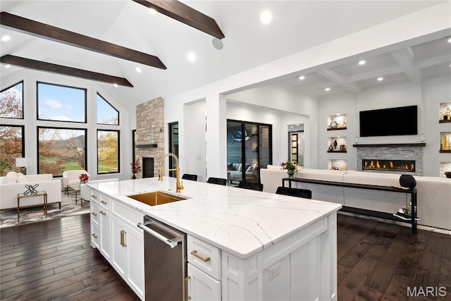 kitchen with open floor plan, a fireplace, a sink, beam ceiling, and dark wood-style flooring