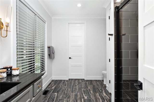 bathroom featuring baseboards, crown molding, toilet, recessed lighting, and vanity