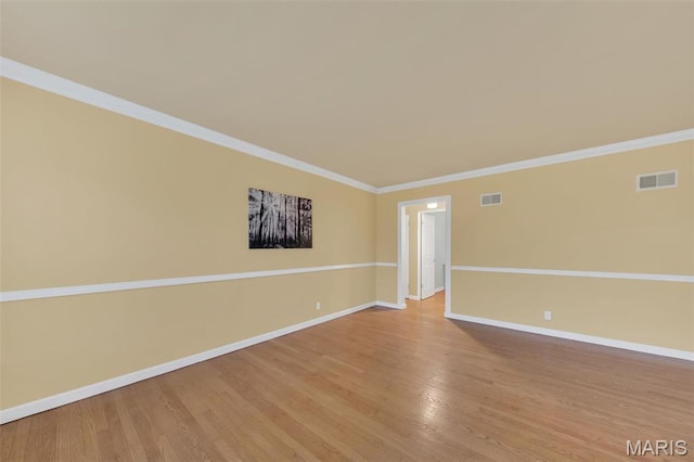 unfurnished room with baseboards, wood finished floors, and ornamental molding