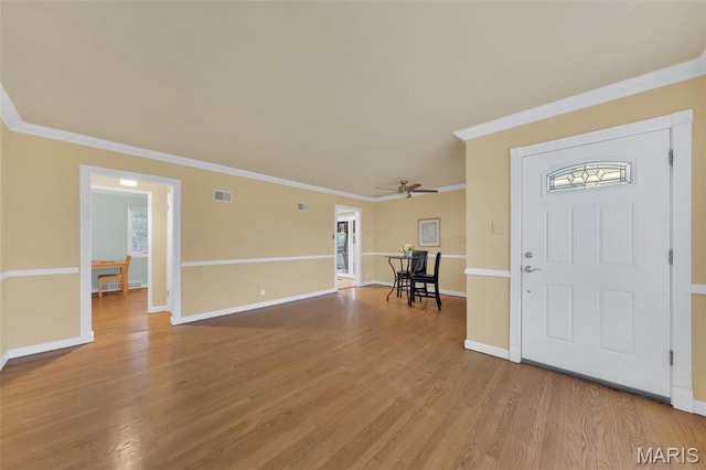foyer entrance with crown molding, ceiling fan, light wood-type flooring, and baseboards