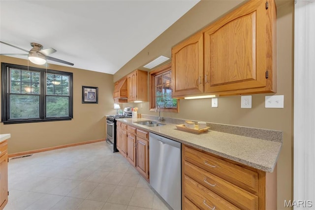 kitchen with stainless steel appliances, a sink, ceiling fan, and plenty of natural light
