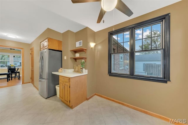 kitchen with freestanding refrigerator, baseboards, light countertops, and a ceiling fan