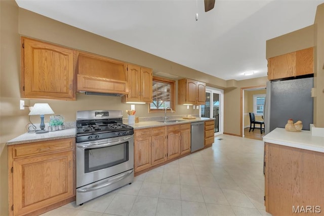 kitchen with appliances with stainless steel finishes, a sink, light countertops, and ceiling fan