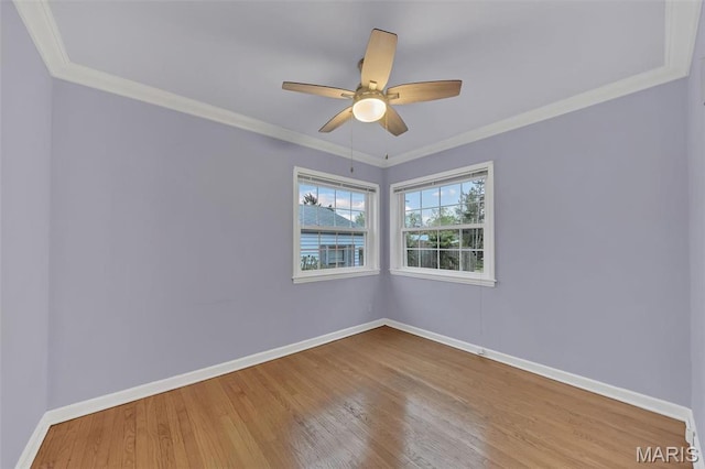 empty room featuring baseboards, wood finished floors, ornamental molding, and a ceiling fan