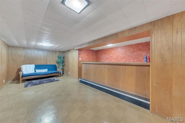 unfurnished room featuring tile patterned floors and wood walls