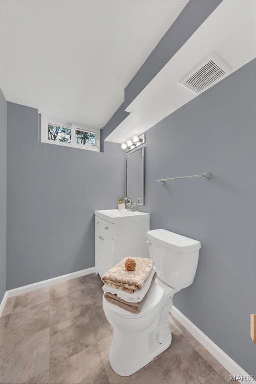 bathroom with toilet, vanity, and baseboards