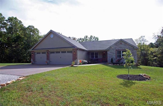 view of front of home with a garage, driveway, a front yard, and brick siding