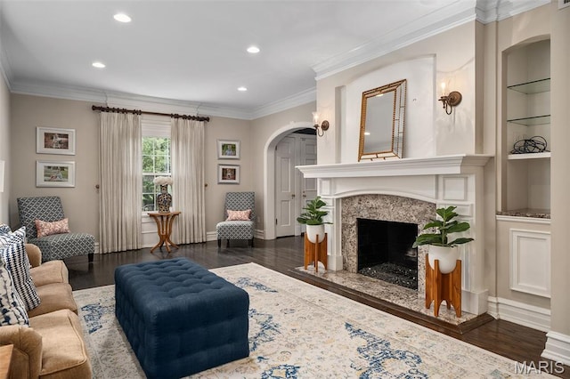 582 S Berry Rd, Webster Groves, MO 63122 - living area with arched walkways, recessed lighting, a high end fireplace, built in features, and wood finished floors